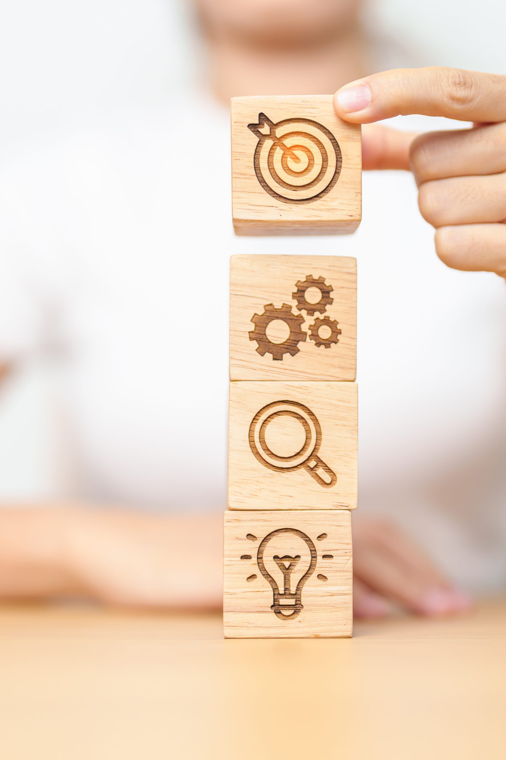 Woman hand holding dartboard above Gear, magnifying and Lightbulb icon block. business planning process, goal, strategy, target, mission, action, research, teamwork and idea concept